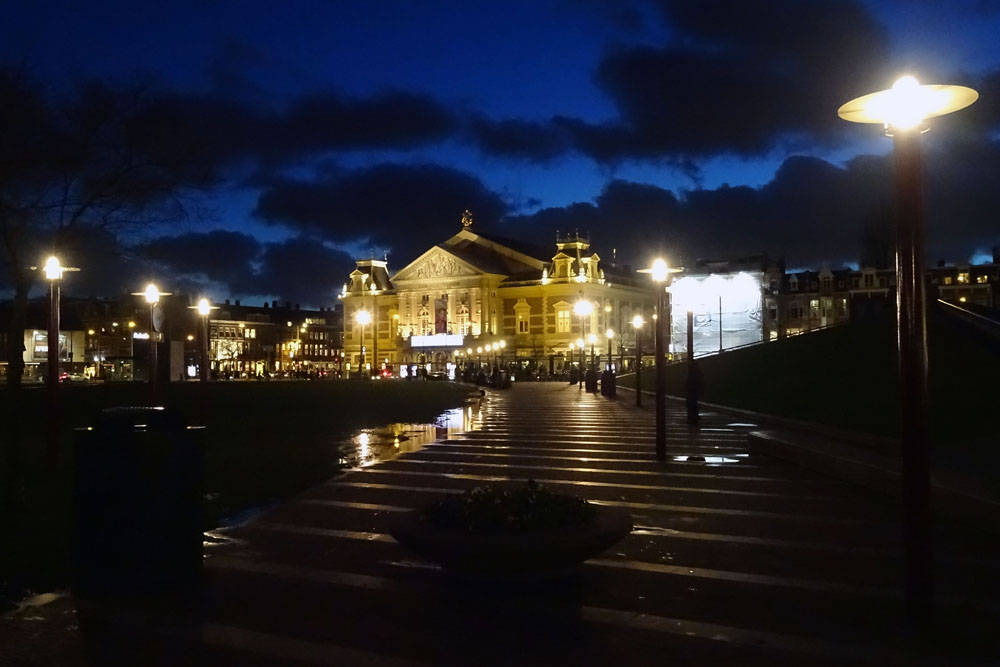 Concertgebouw bij avond met donkere wolken